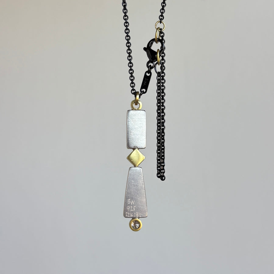 Necklace with geometric pendants on a gray background