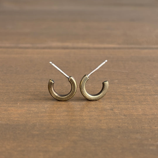 Pair of gold hoop earrings on a wooden surface