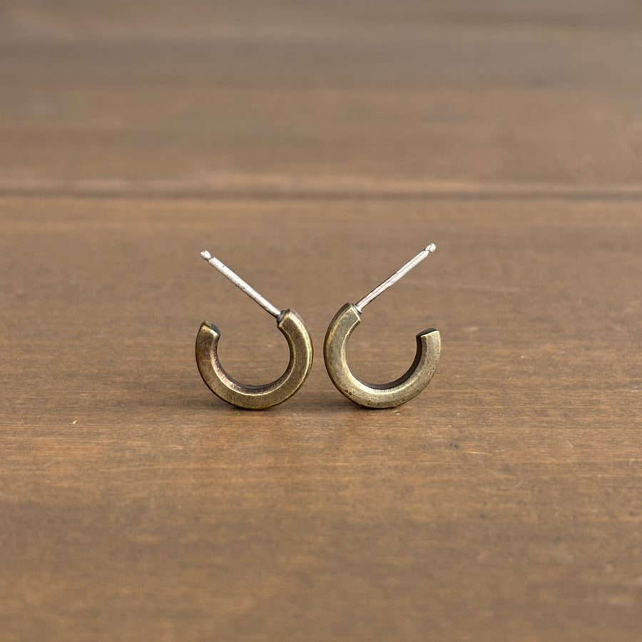 Pair of gold hoop earrings on a wooden surface