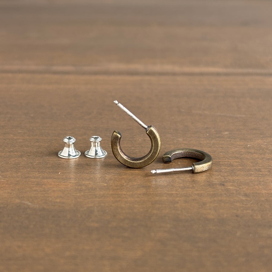 Pair of gold hoop earrings on a wooden surface