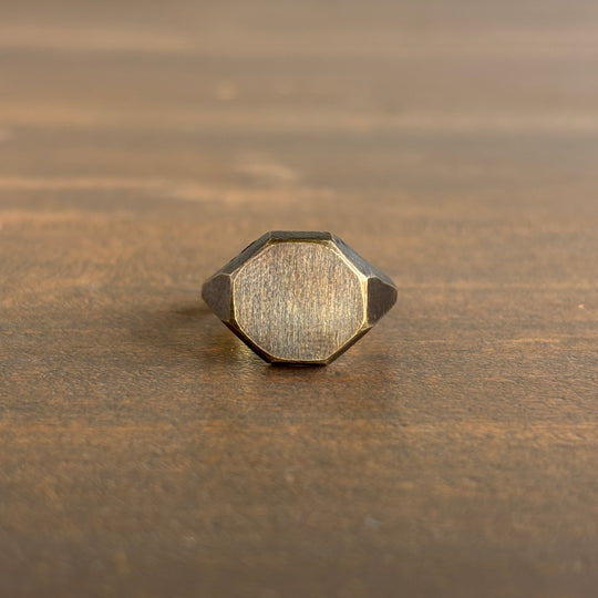 Hexagonal gold ring on a wooden surface