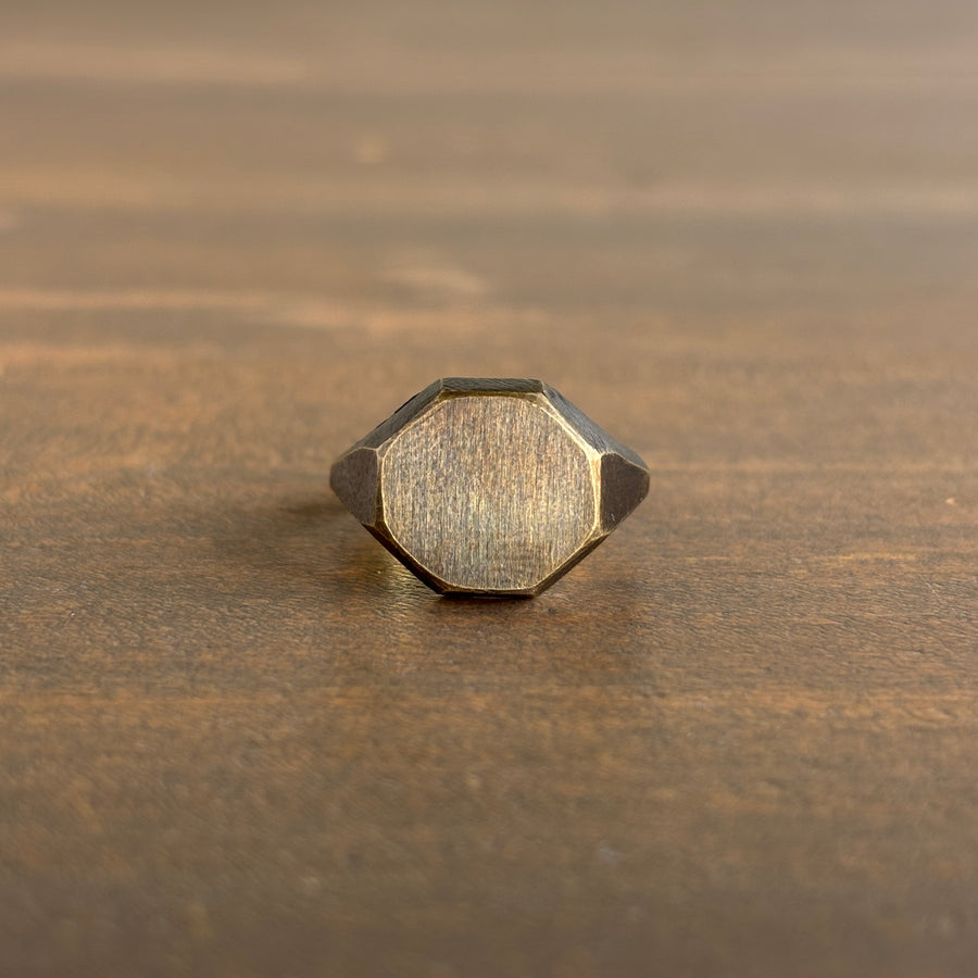 Hexagonal gold ring on a wooden surface