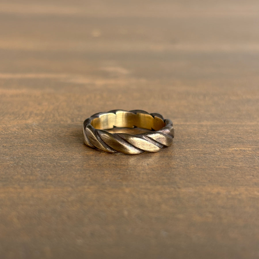 brass twisted ring on a wooden surface