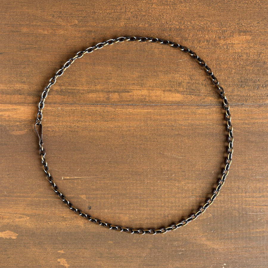 Silver chain necklace on a wooden surface