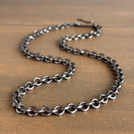 Silver chain necklace on a wooden surface