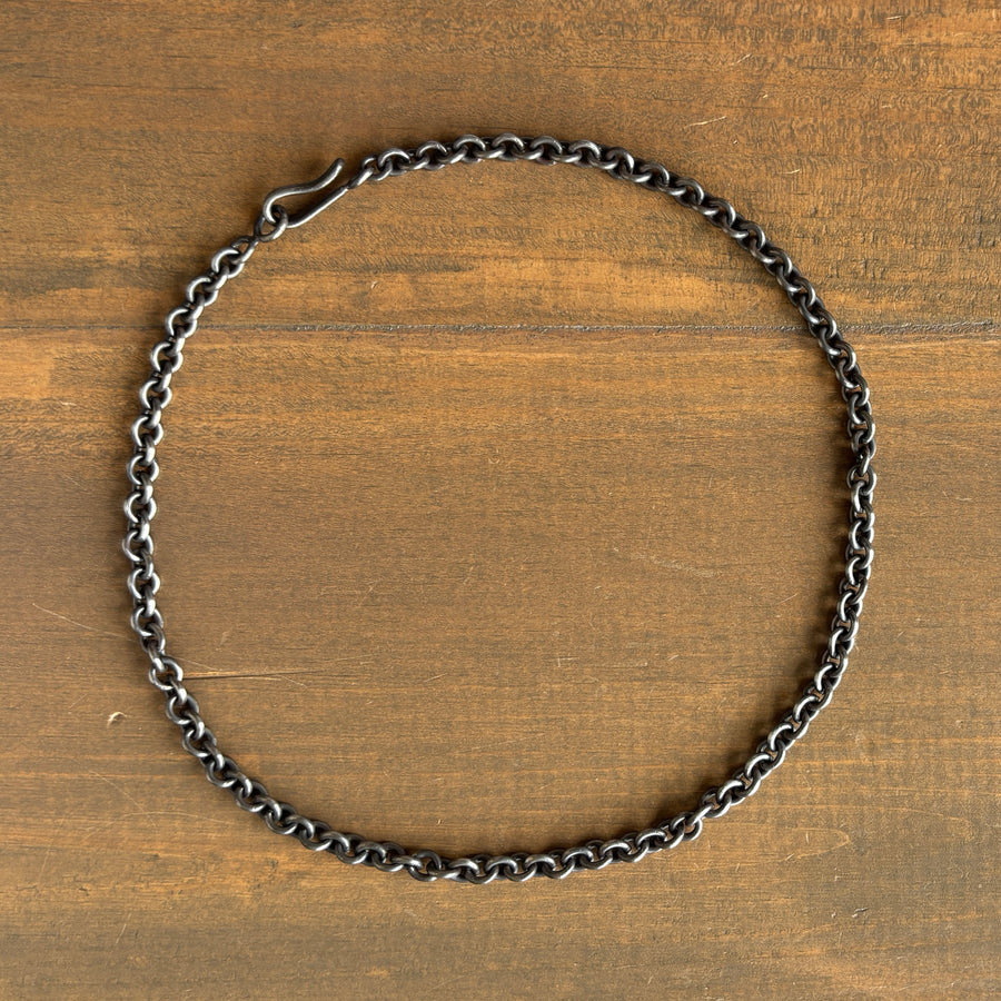 Silver chain necklace on a wooden surface