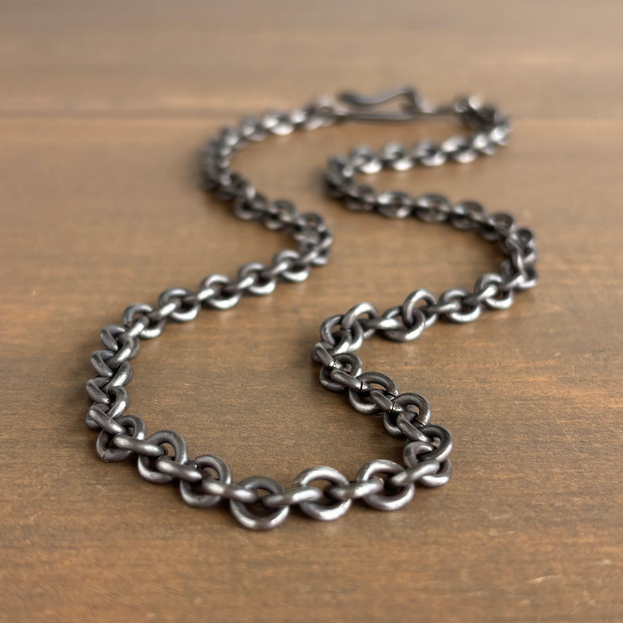 Silver chain necklace on a wooden surface