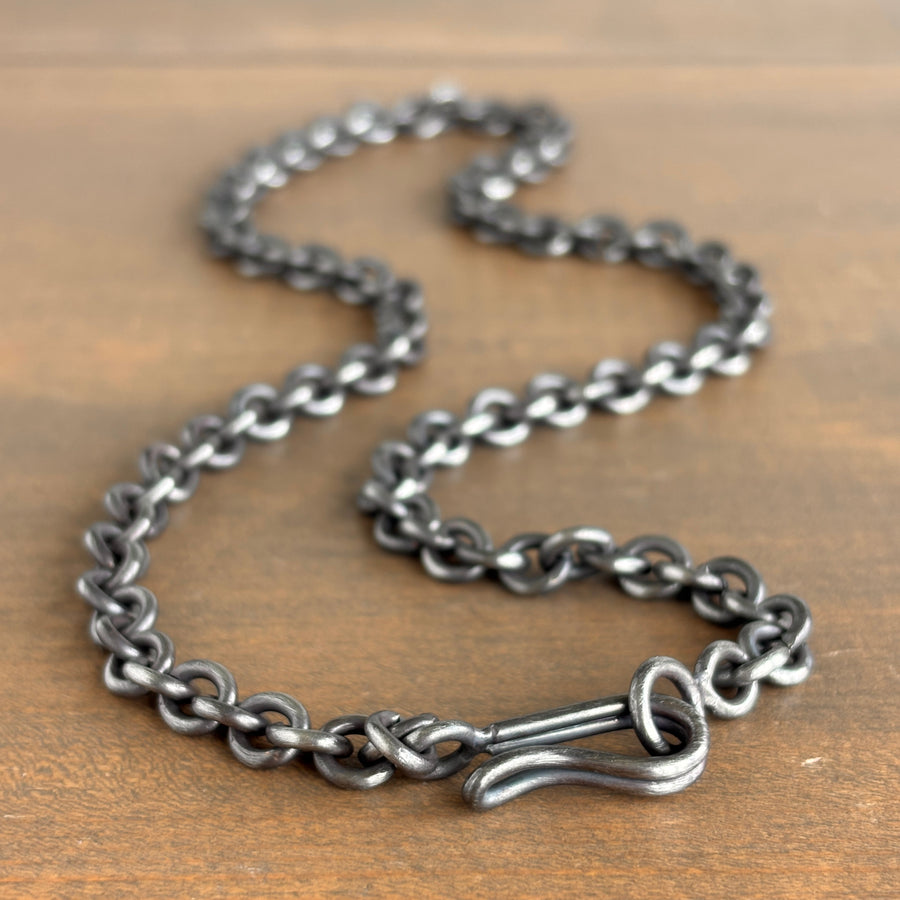 Silver chain necklace on a wooden surface