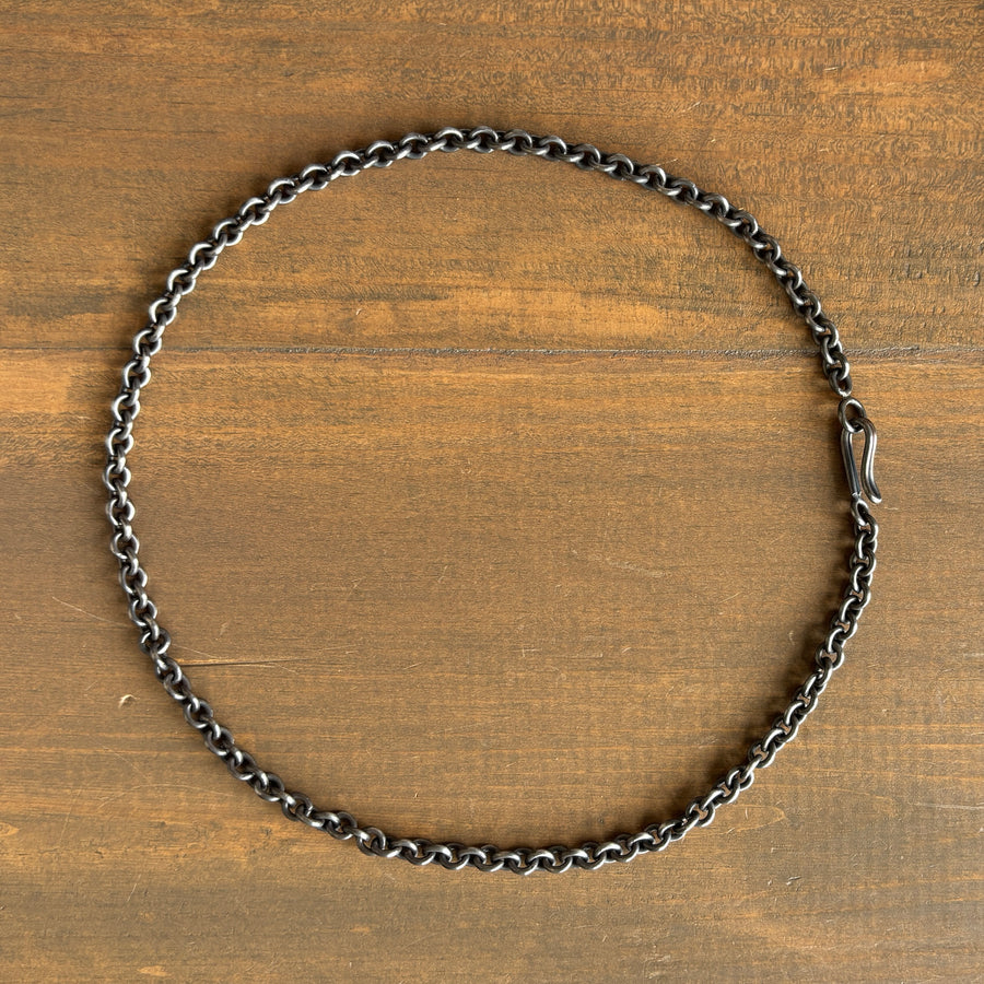 Silver chain necklace on a wooden surface