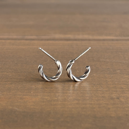 Pair of silver hoop earrings on a wooden surface