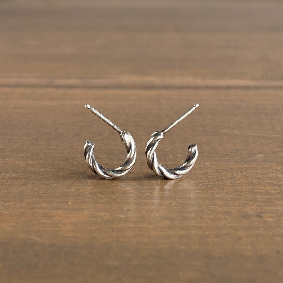 Pair of silver hoop earrings on a wooden surface