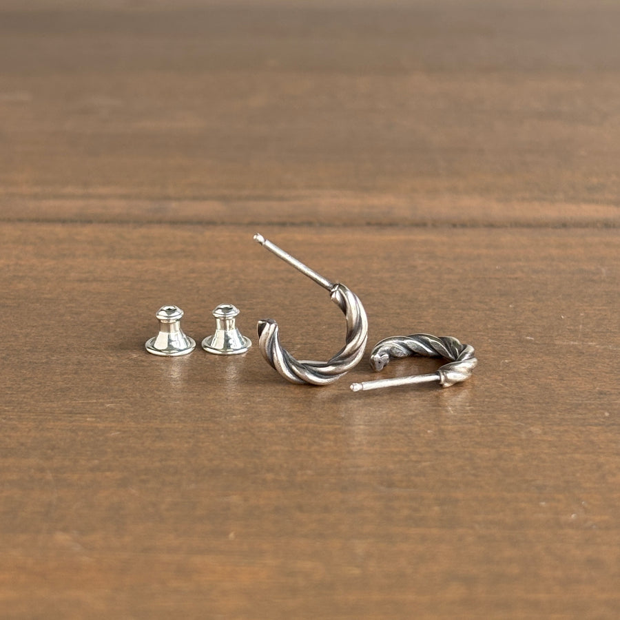 Silver hoop earrings on a wooden surface