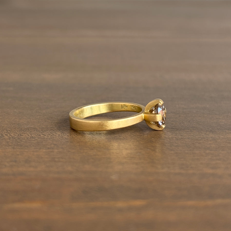 Gold ring with a diamond on a wooden surface