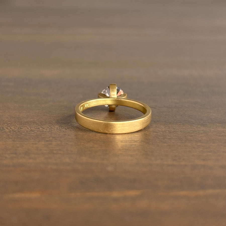 Gold ring with a diamond on a wooden surface