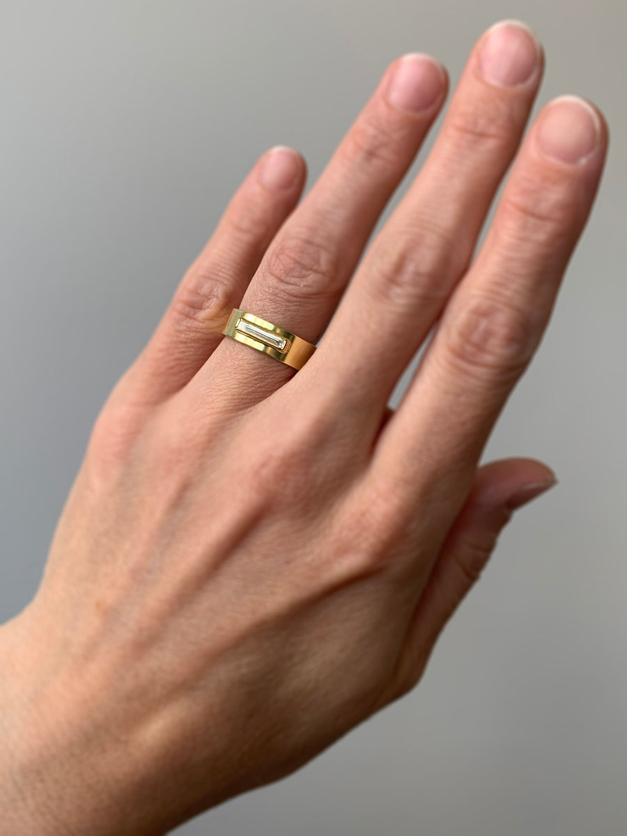 Gold diamond ring with a rectangular engraving on hand
